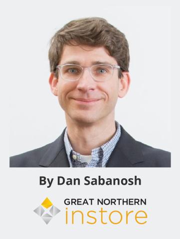 a man wearing glasses and smiling at the camera