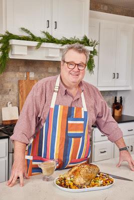 Eric Stonestreet standing in front of a plate of food