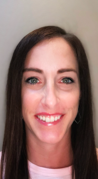 a close up of a woman who is smiling and looking at the camera