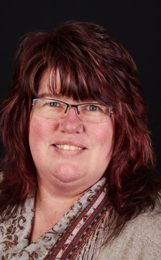 a person wearing glasses and smiling at the camera