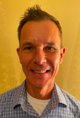 a man wearing a striped shirt and smiling at the camera
