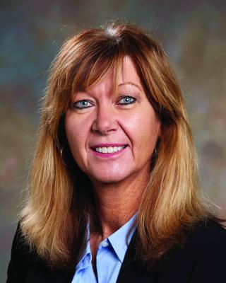a person wearing a suit and tie smiling at the camera