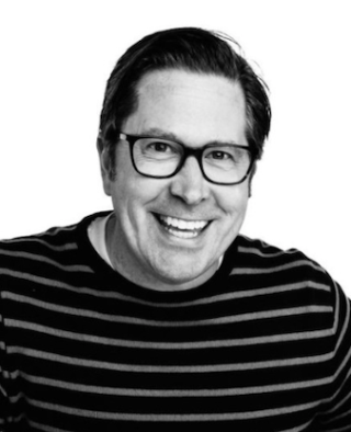 a man in glasses looking at the camera