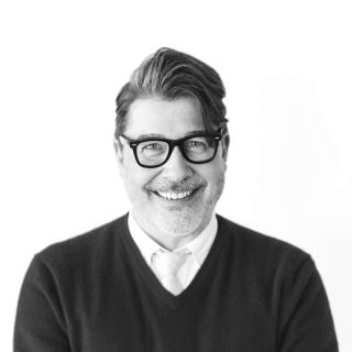 a man wearing glasses posing for the camera