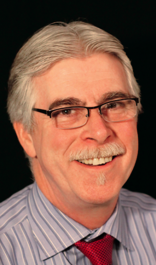 a man wearing glasses and looking at the camera