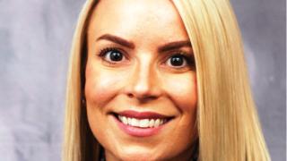 a close up of a woman who is smiling and looking at the camera