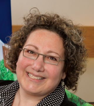 a person wearing glasses and smiling at the camera