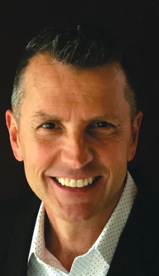 a man who is smiling and looking at the camera