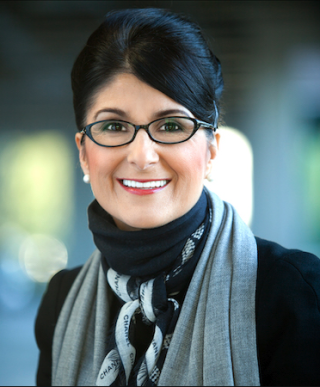 a person wearing glasses and smiling at the camera